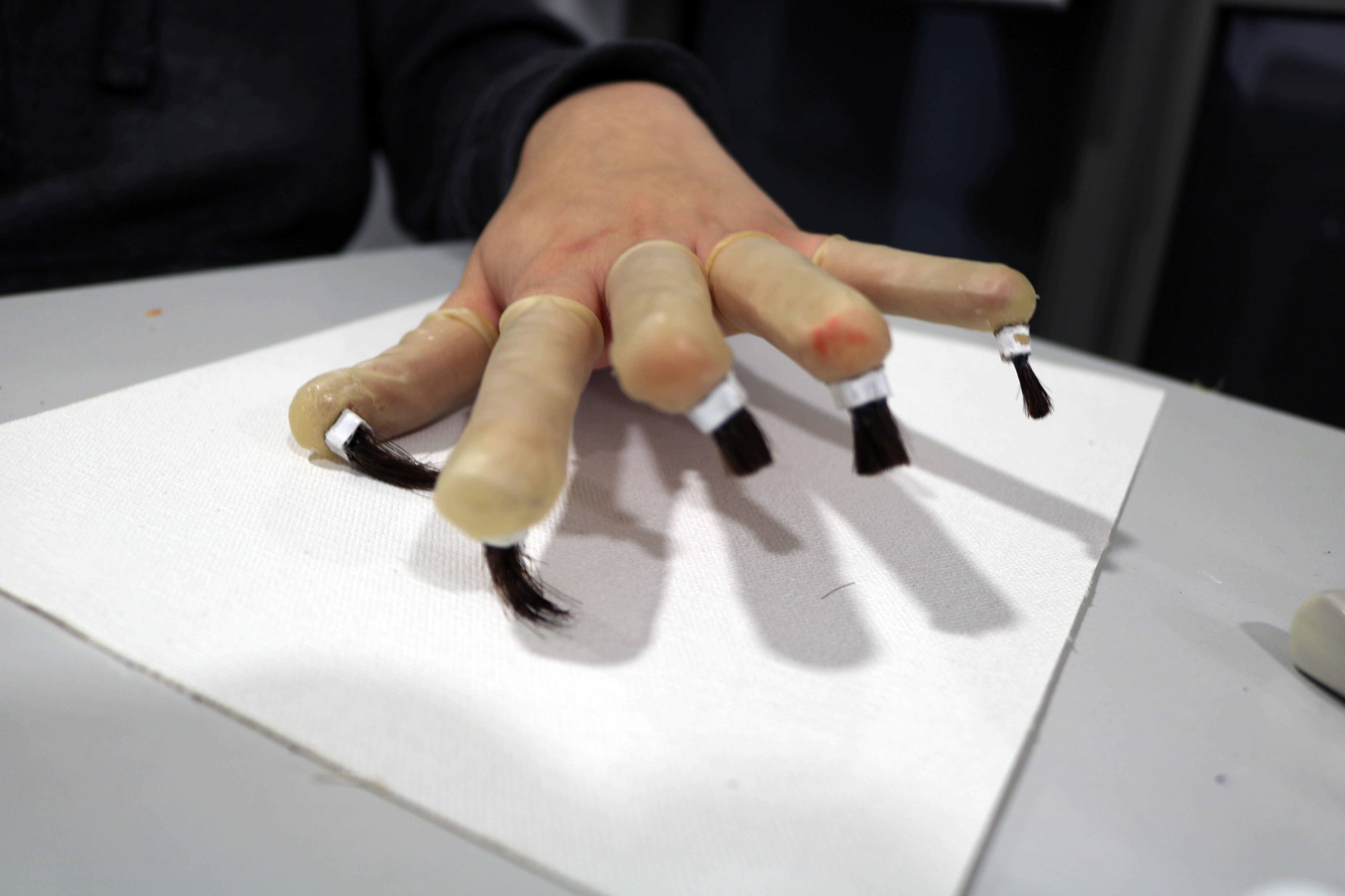 Prototype of finger brushes made of hair and carboard, glued to finger cots