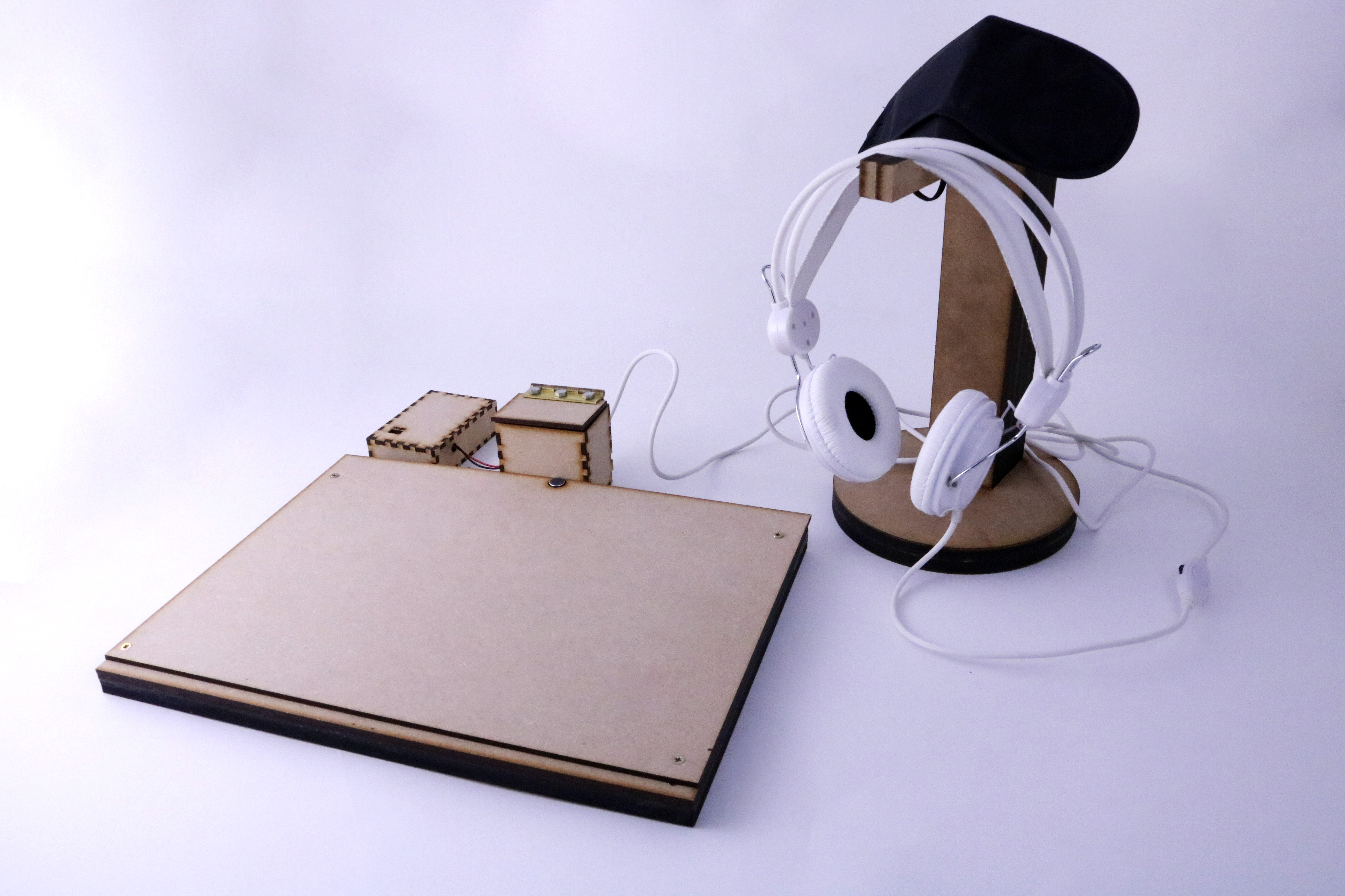 Board made of wood with headphones on a wooden headphone stand, in front of a purple background