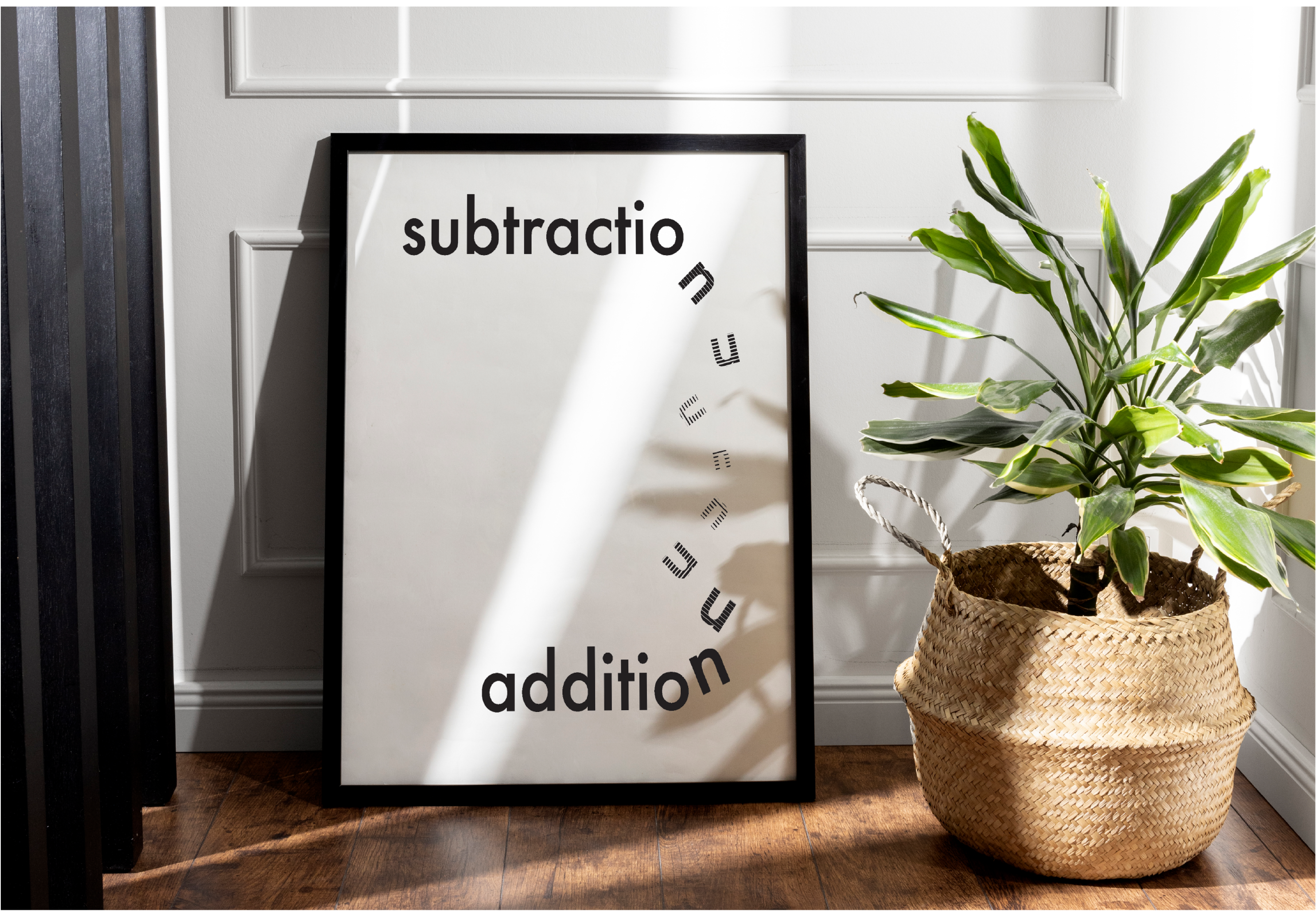 Prototype of the visual typography poster in a frame, resting on the floor, next to a plant